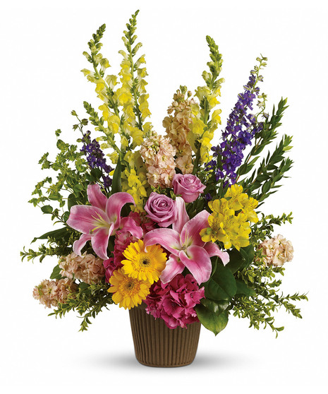 colorful floral tribute with towering flowers accented with lilies