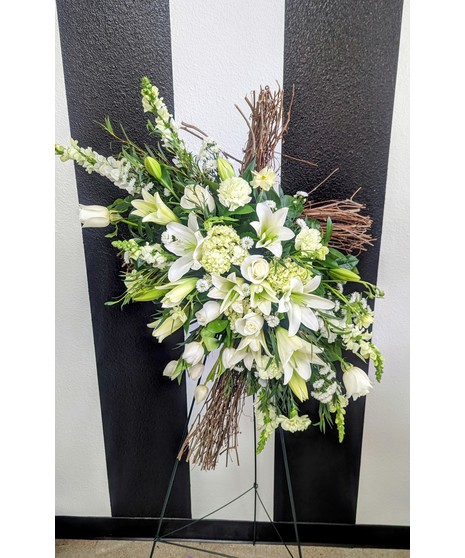grapevine cross decorated with spray of colorful flowers appropriate for funeral services